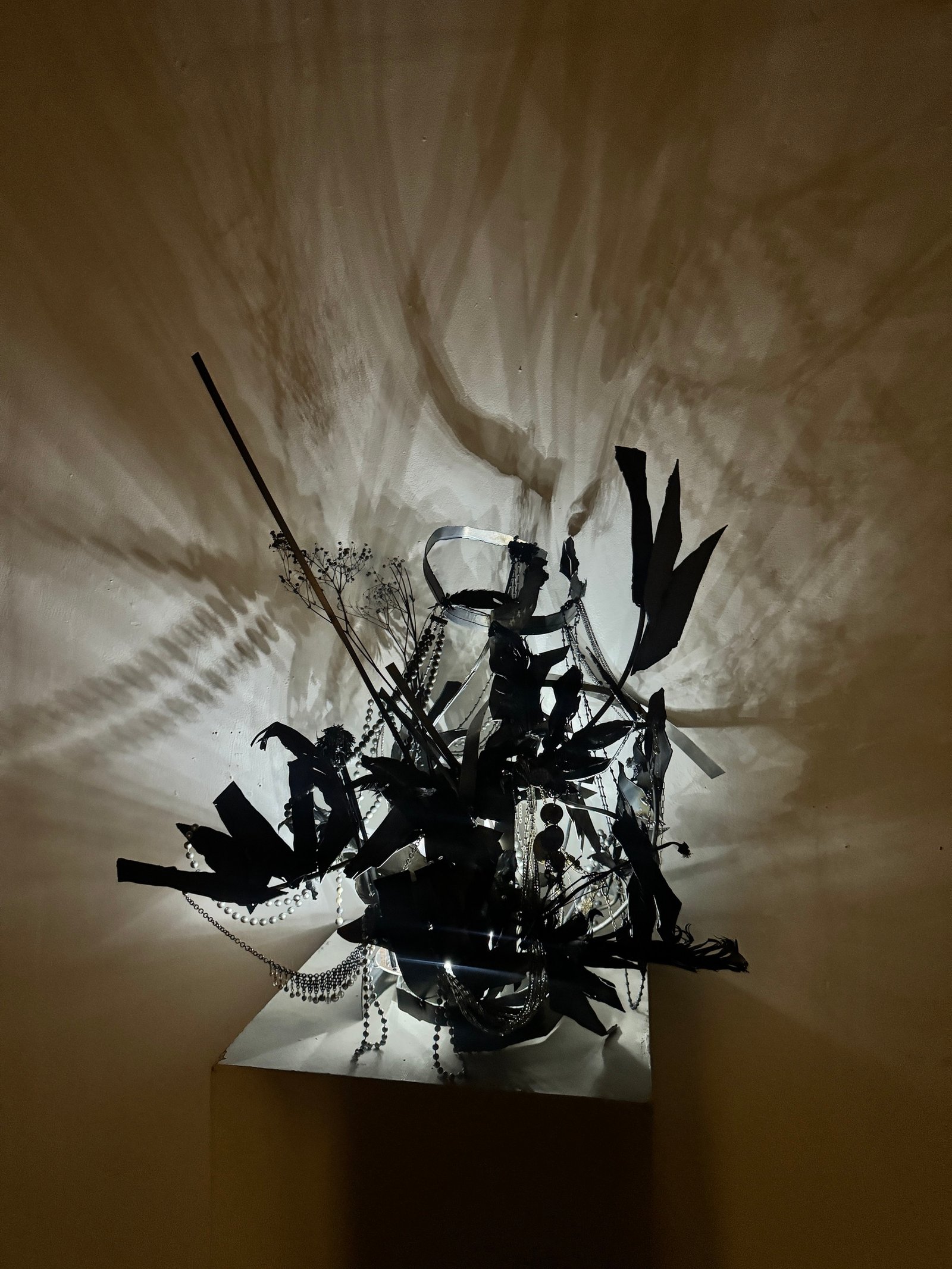Black sculpture casting shadows on the wall